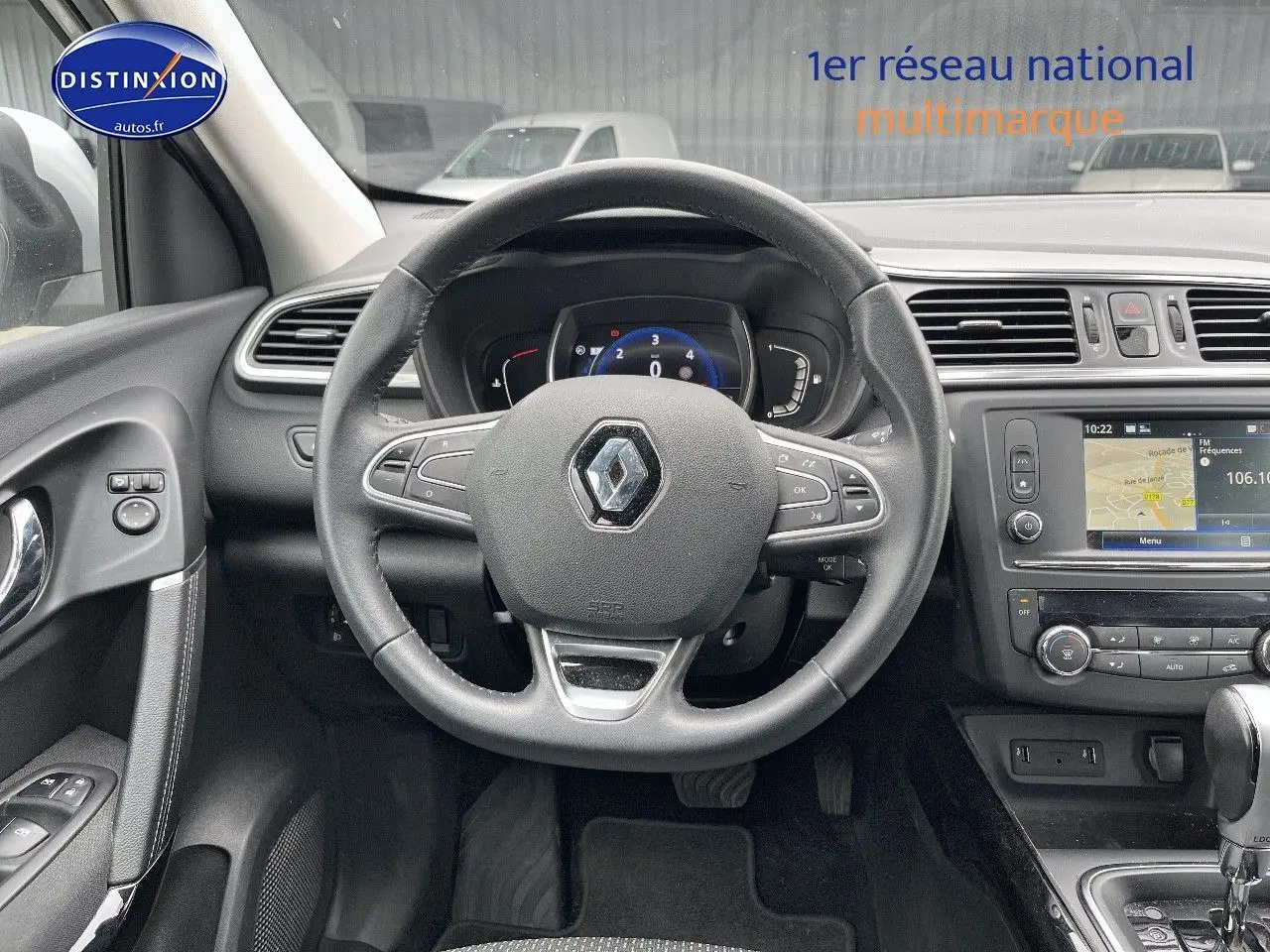Vue intérieure centrée sur le volant cuir multifonction d’un Renault Kadjar gris Platine de 2018 avec écran tactile et commandes au volant.