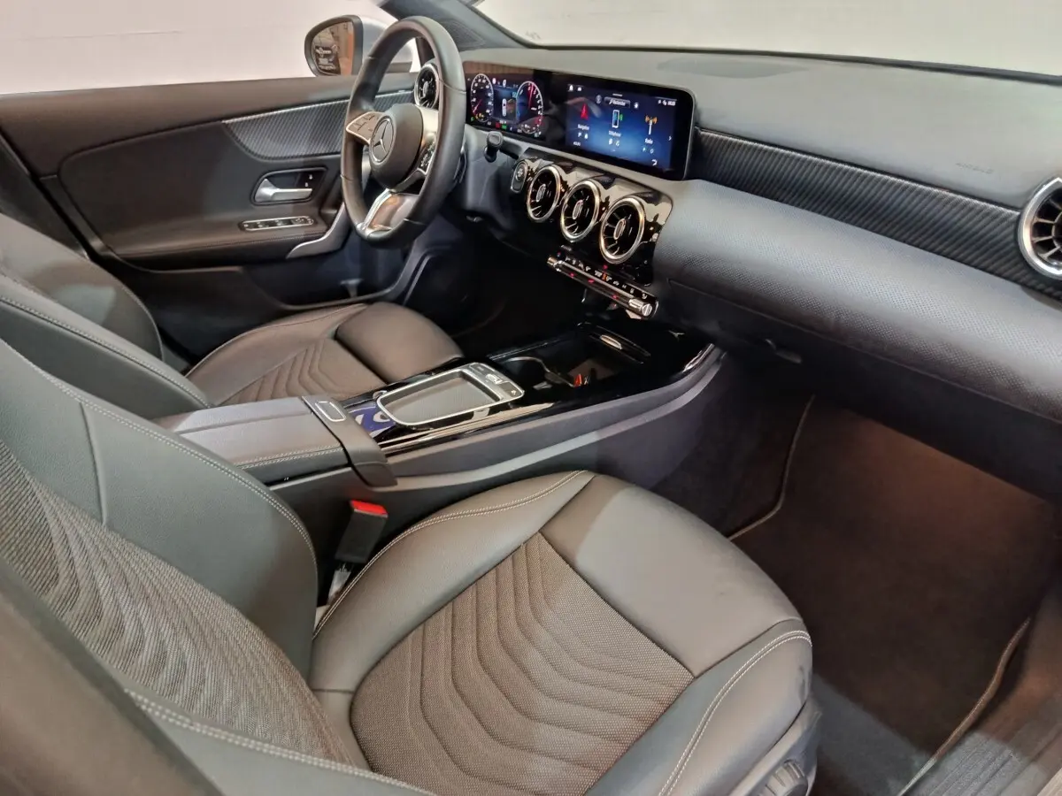 Vue intérieure côté conducteur de la Mercedes Classe A 250 e Business Line 2023, avec tableau de bord numérique et volant cuir alu.