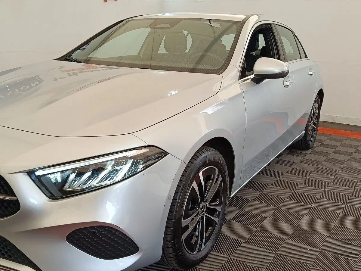 Vue 3/4 avant droit d'une Mercedes Classe A A 250 e Business Line gris clair avec phares LED et jantes noires.