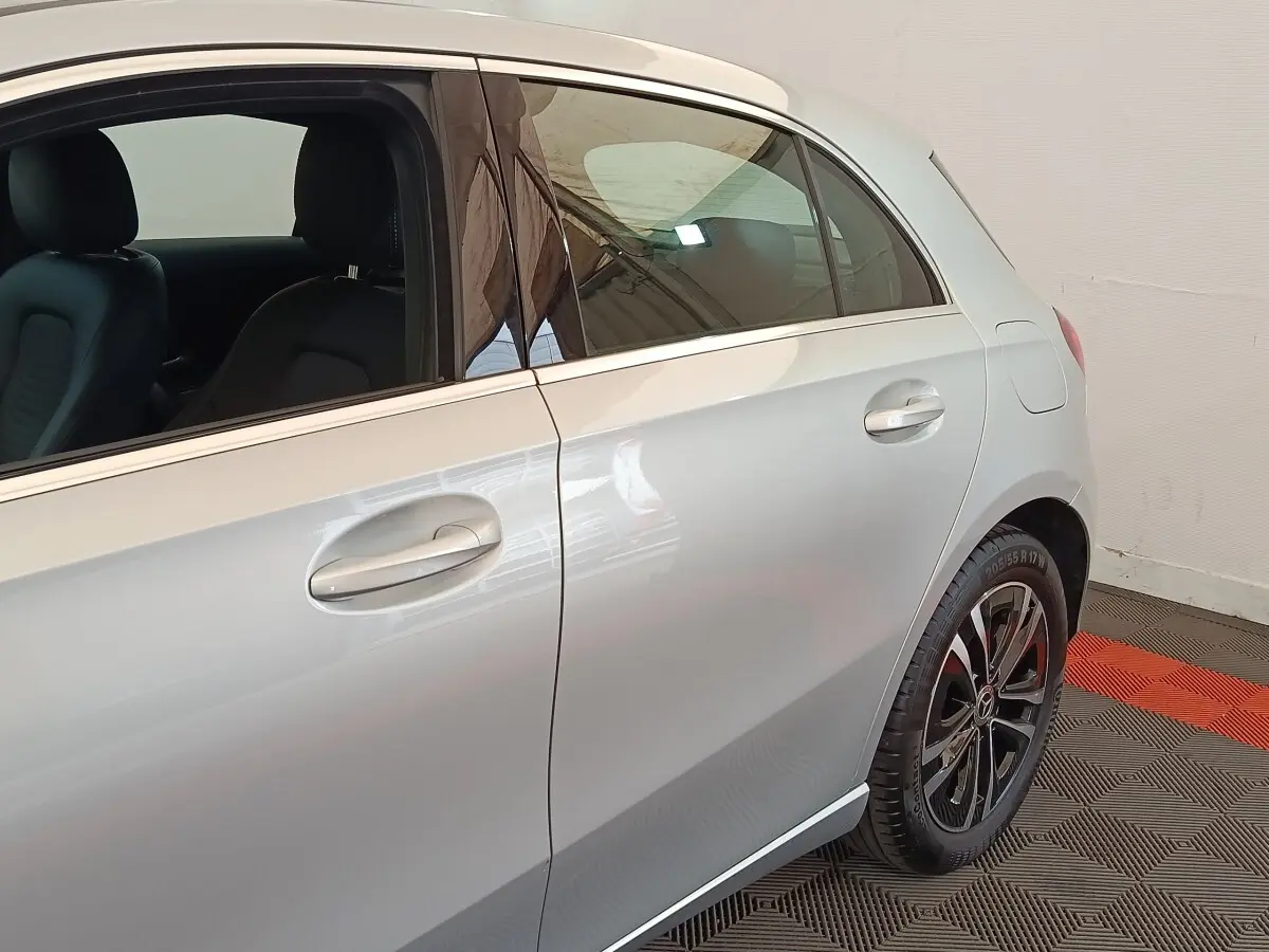 Vue latérale côté droit d'une Mercedes Classe A 250 e Business Line gris clair avec jantes alliage noires et intérieurs cuir noirs.