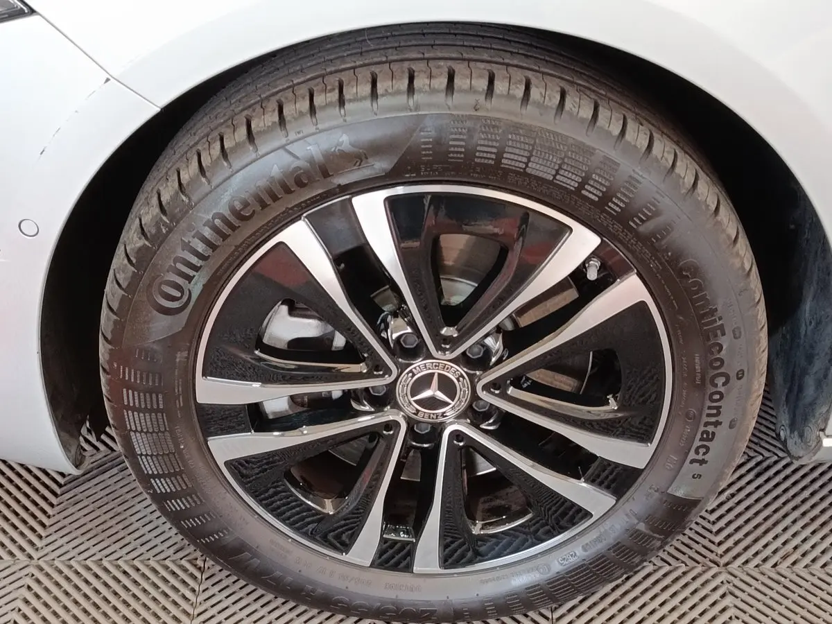 Gros plan sur la jante alliage noir et argentée d'une Mercedes Classe A gris clair, roue avant droite visible.