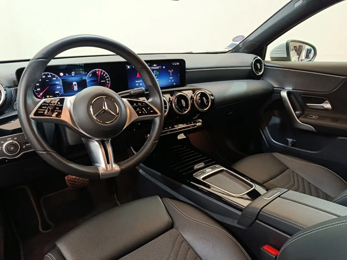Vue intérieure côté conducteur de la Mercedes Classe A 250 e Business Line 2023, volant cuir alu et écran tactile double.