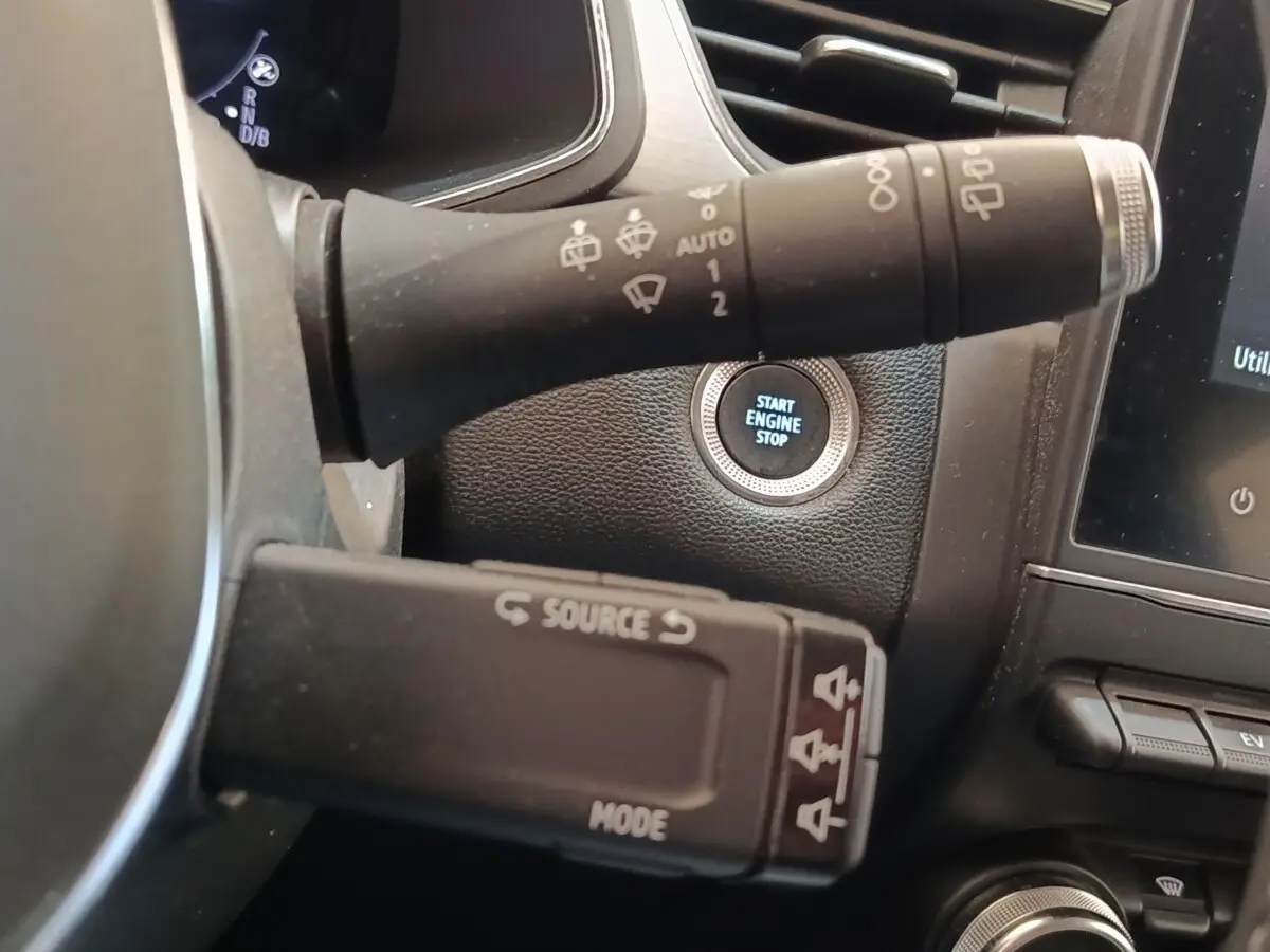 Gros plan intérieur sur le bouton start/stop et les commandes au volant du Renault Captur gris clair Intens E-TECH 2021.
