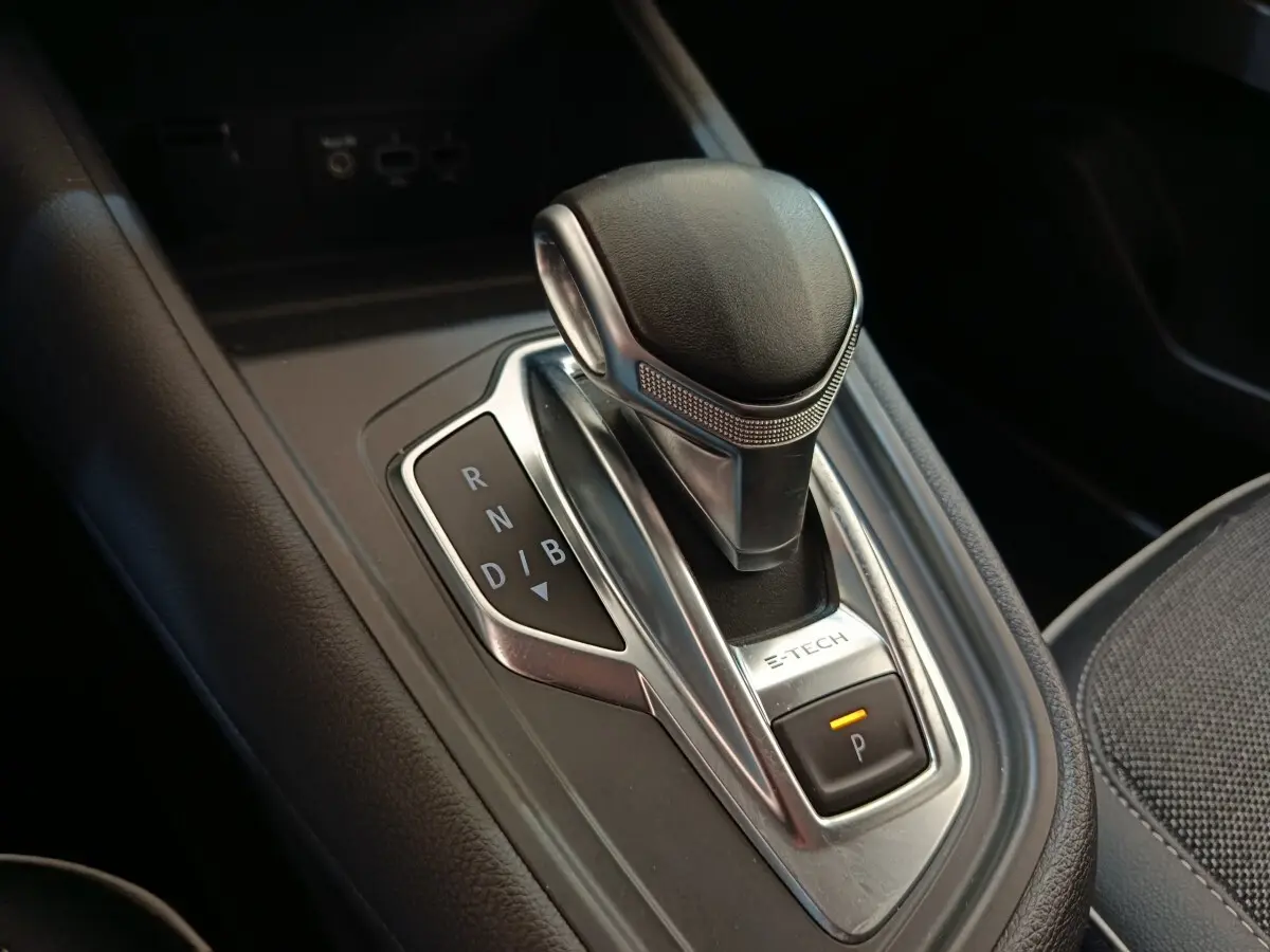Gros plan sur le levier de vitesses automatique E-TECH du Renault Captur gris clair, avec indication des modes de conduite.