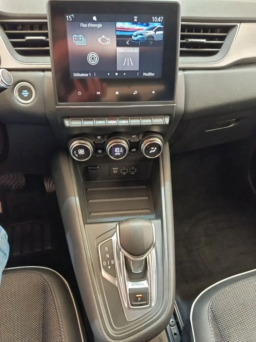 Vue intérieure centrée sur la console centrale du Renault Captur Intens E-TECH 2021 avec écran tactile et levier de vitesses automatique.