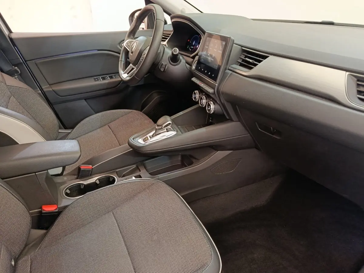 Vue intérieure côté conducteur du Renault Captur Intens E-TECH 2021, montrant tableau de bord noir et écran tactile central.