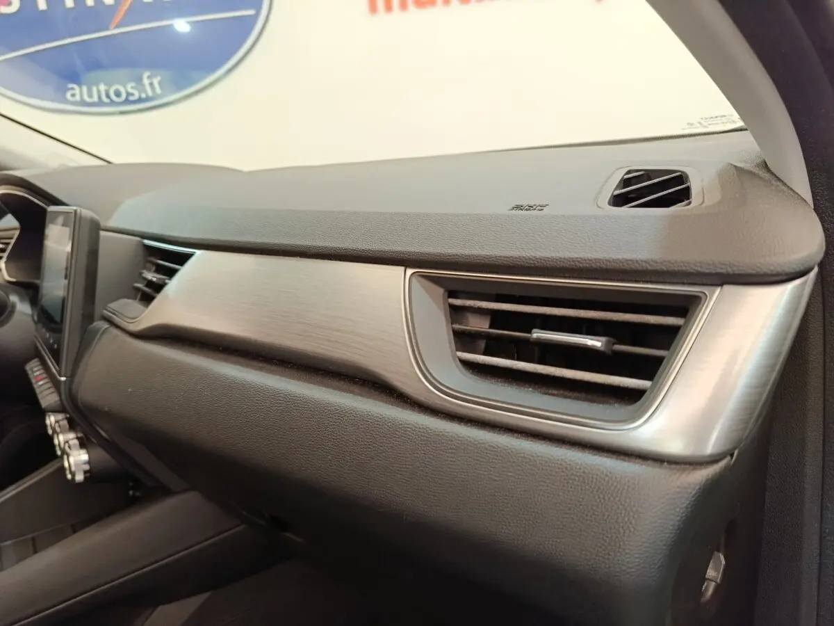 Vue intérieure du tableau de bord côté passager du Renault Captur gris clair, avec aérateur et finition métal brossé.
