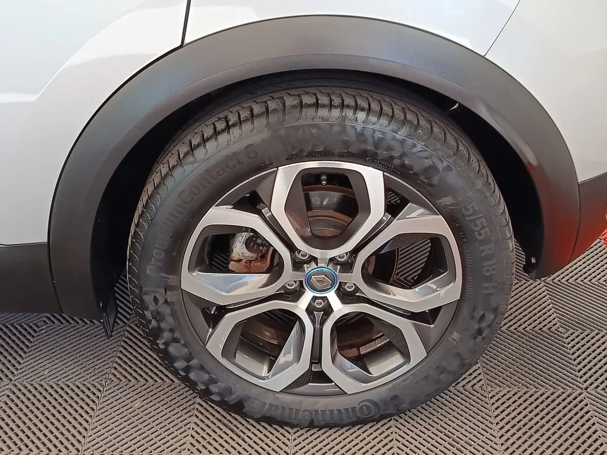 Gros plan sur la roue arrière droite d’un Renault Captur gris clair, jante alliage à cinq branches doubles.