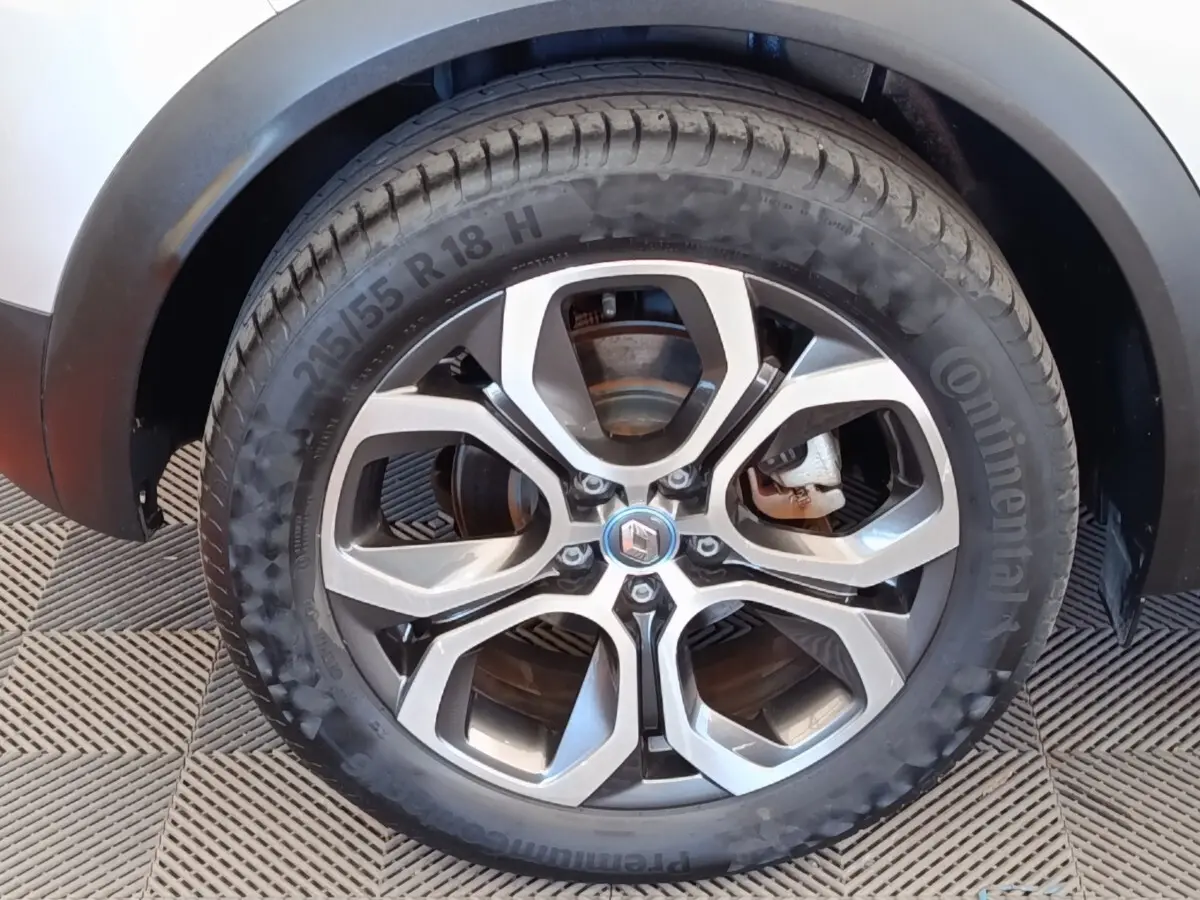 Gros plan sur la roue avant droite gris clair du Renault Captur Intens E-TECH Plug-in 160 avec jante alliage distinctive.