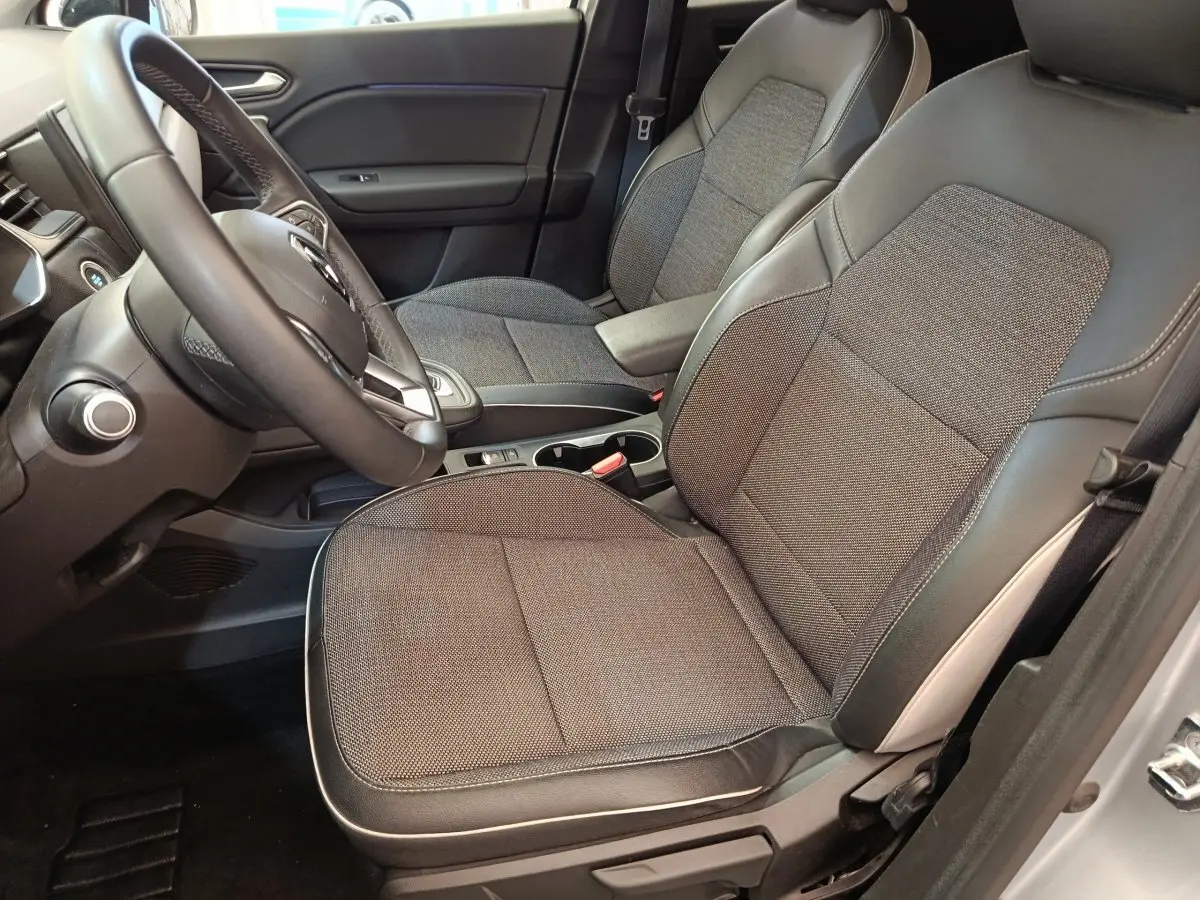 Vue intérieure côté conducteur du Renault Captur Intens E-TECH 2021, sièges tissu gris et cuir noir, volant multifonctions.