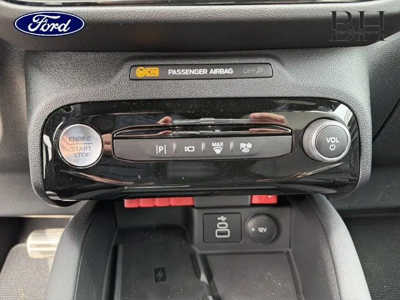 Détail du tableau de bord noir brillant du Ford Kuga 2026 avec bouton start/stop et commandes climatisation.