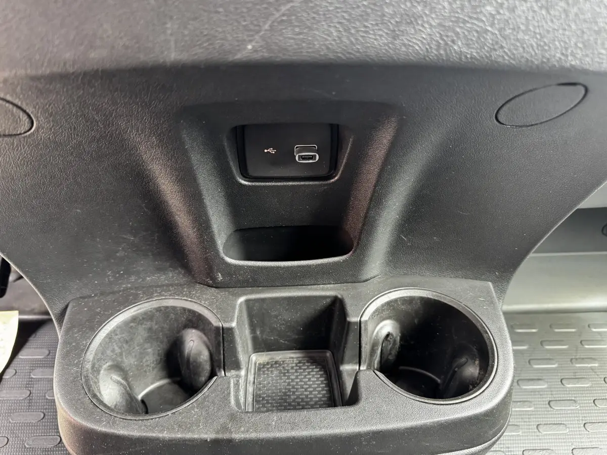 Gros plan sur le porte-gobelets noir avec prise USB intégré dans l’habitacle du Citroën Jumper blanc.