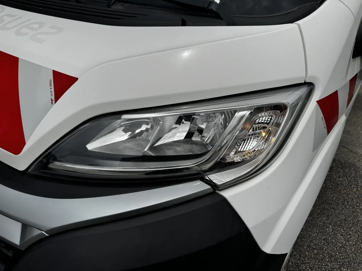 Gros plan sur le phare avant droit blanc du Citroën Jumper 2019 avec marquages rouges sur la carrosserie.