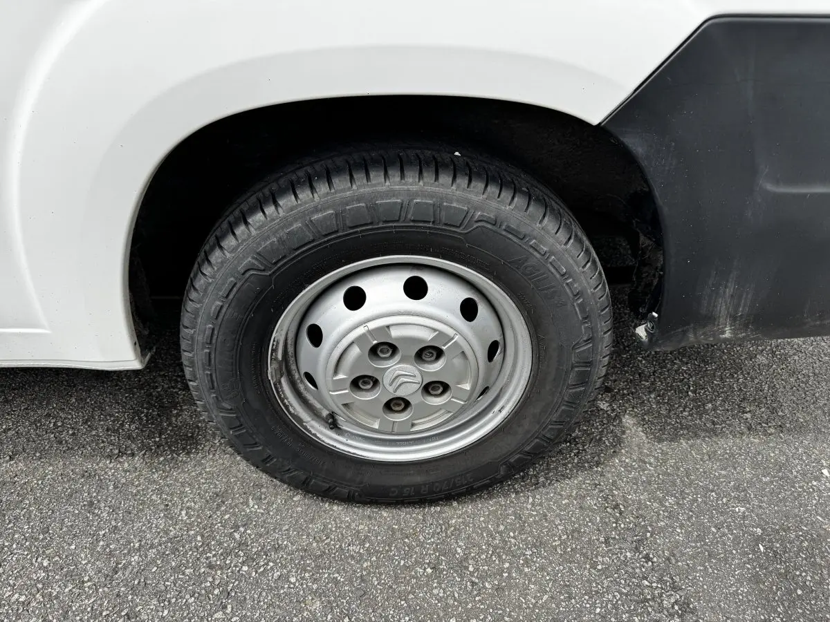Gros plan sur la roue avant droite en jante acier du Citroën Jumper blanc, avec logo Citroën au centre.