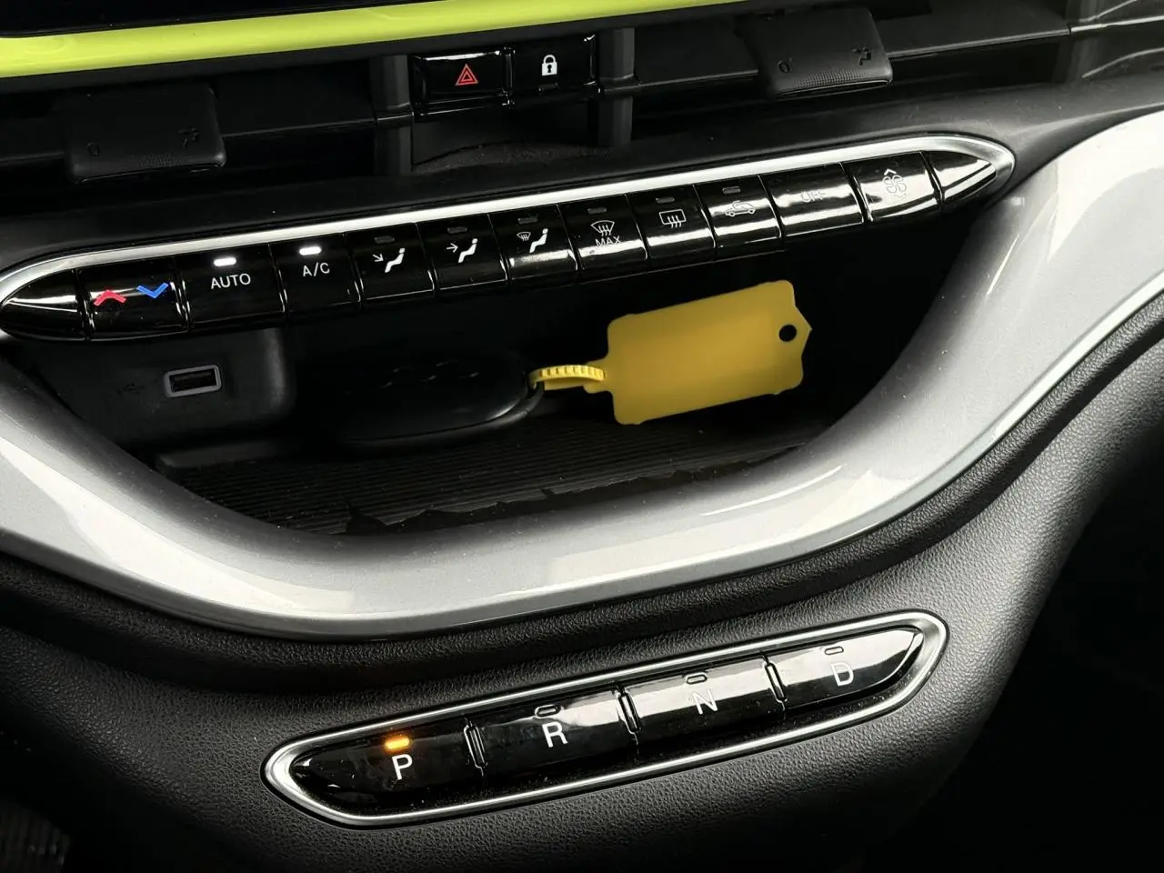 Gros plan sur la console centrale de la Fiat 500 électrique 2024 avec sélecteur de boîte auto et bouton P allumé.