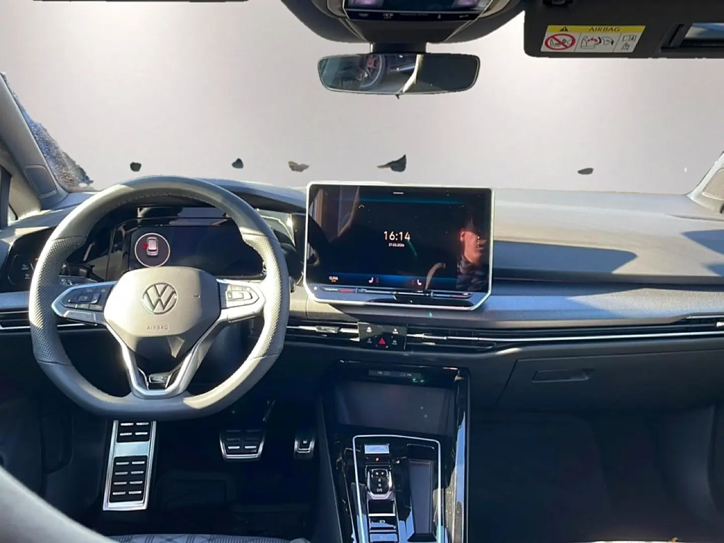 Vue avant de l'intérieur noir de la Volkswagen Golf 1.5 ETSI Evo2 avec volant sport et écran tactile central.