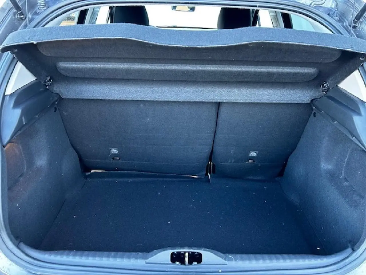 Coffre ouvert vu de l'arrière d'une Citroën C3 gris foncé, montrant l'espace de chargement et la banquette arrière.