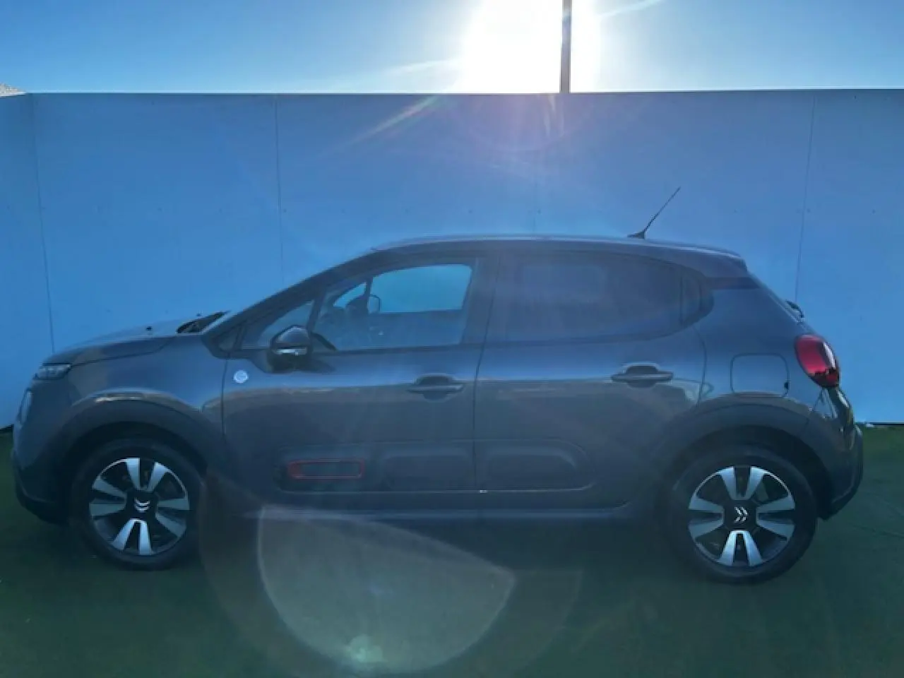 Profil côté gauche d'une Citroën C3 gris foncé 2021 avec jantes alliage et protections latérales spécifiques C-Series.