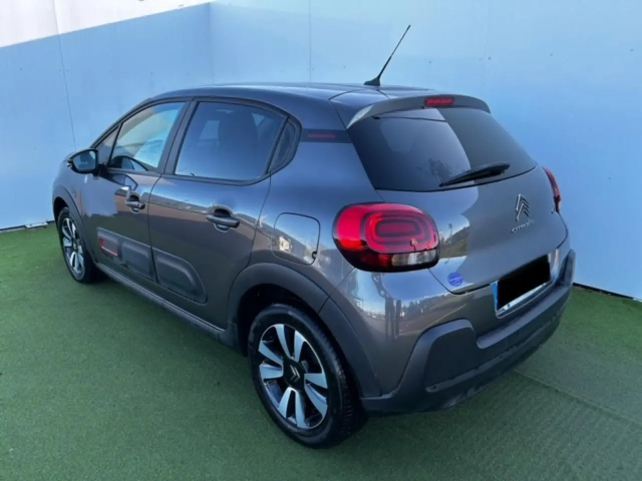 Citroën C3 gris foncé vue 3/4 arrière droit avec jantes alliage et vitres arrière surteintées.
