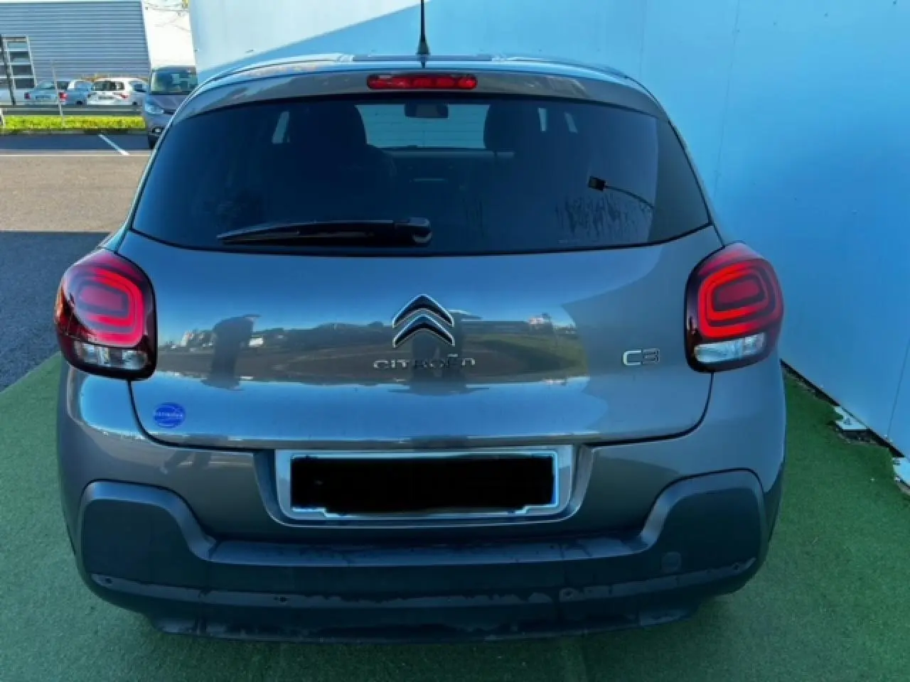 Vue arrière d'une Citroën C3 gris foncé avec feux arrière à effet 3D et logo Citroën bien visible.