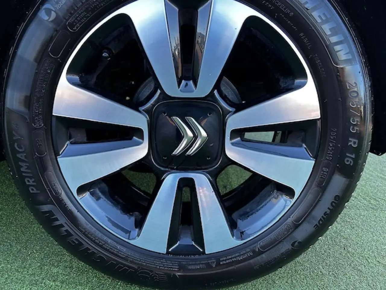 Gros plan sur la jante alliage 16 pouces diamantée noire et argentée avec logo Citroën au centre sur pneu Michelin.