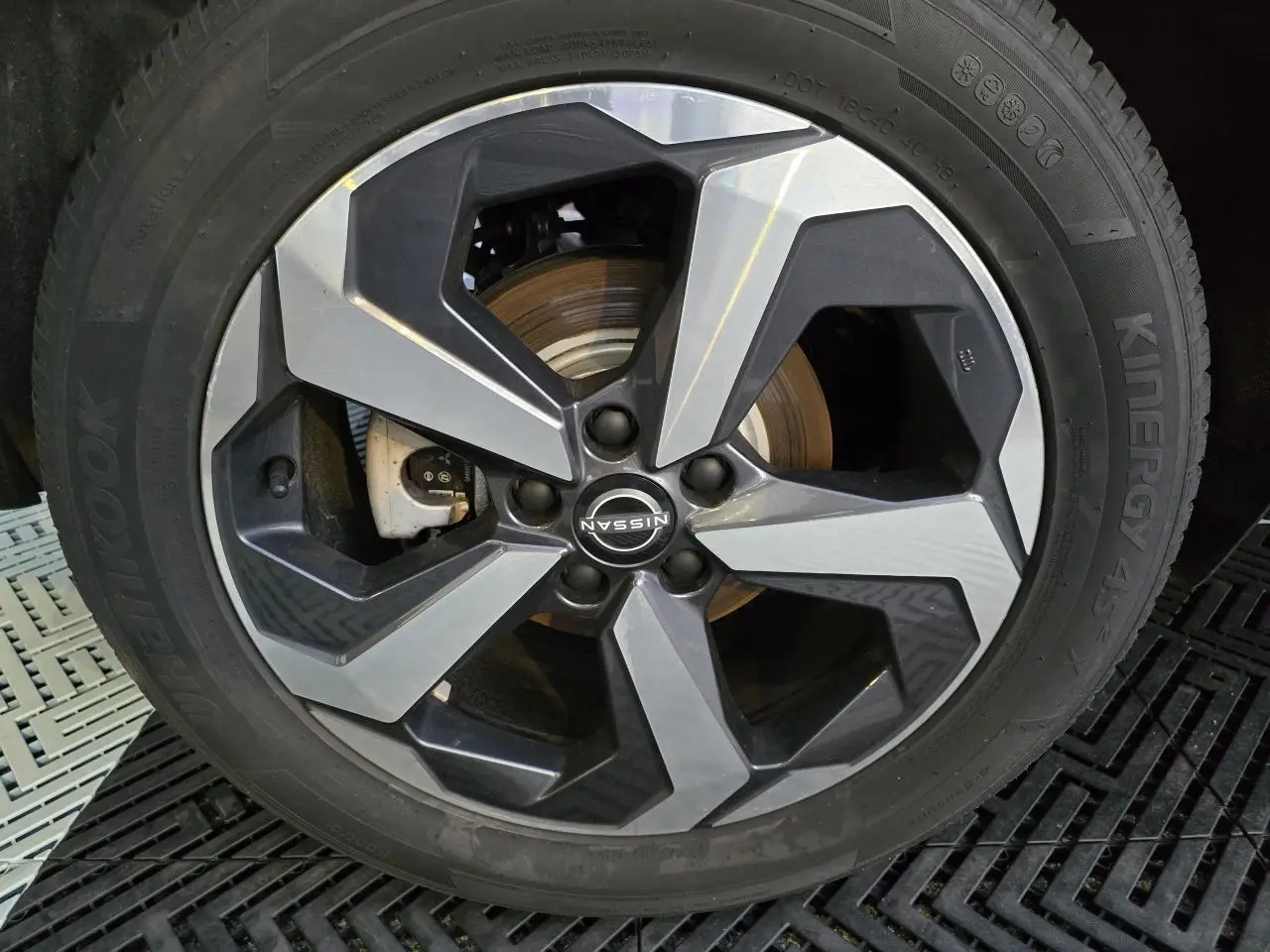 Gros plan sur la jante alliage 18 pouces bicolore du Nissan Qashqai gris silver 2024, avec logo central visible.