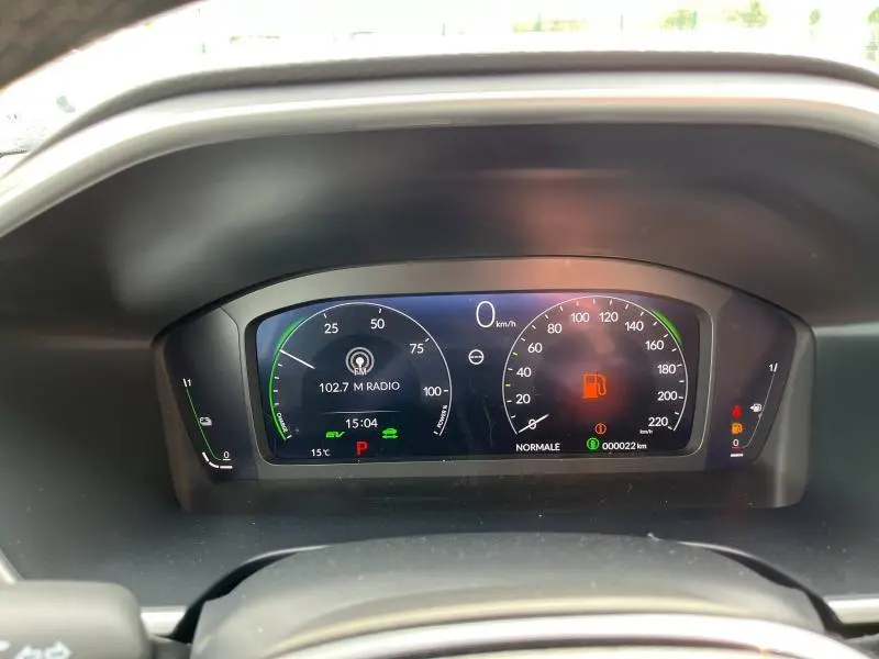 Tableau de bord numérique du Honda CR-V 2024 blanc, affichant vitesse à zéro et alertes de carburant.