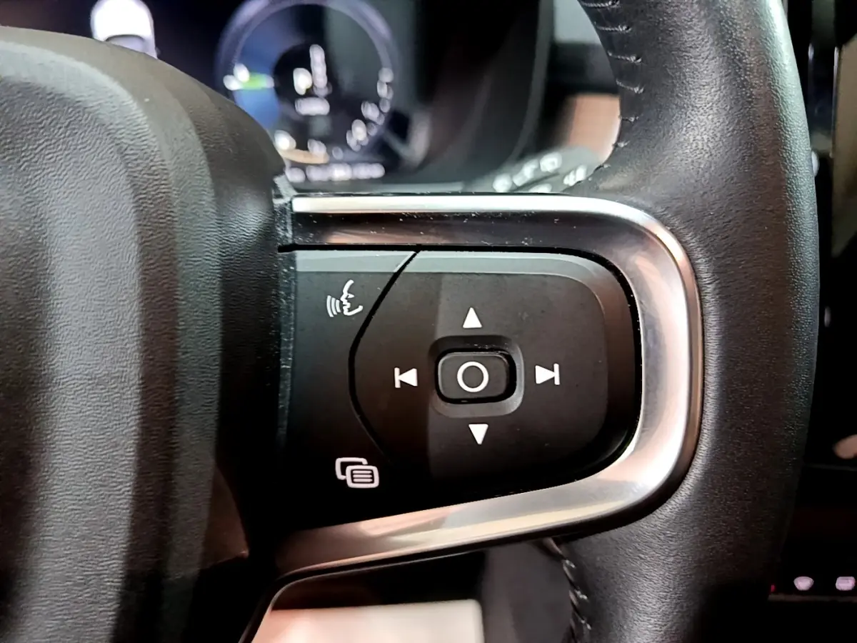 Gros plan sur les commandes vocales et navigation du volant cuir noir du Volvo XC40 Recharge T4 Business 2020