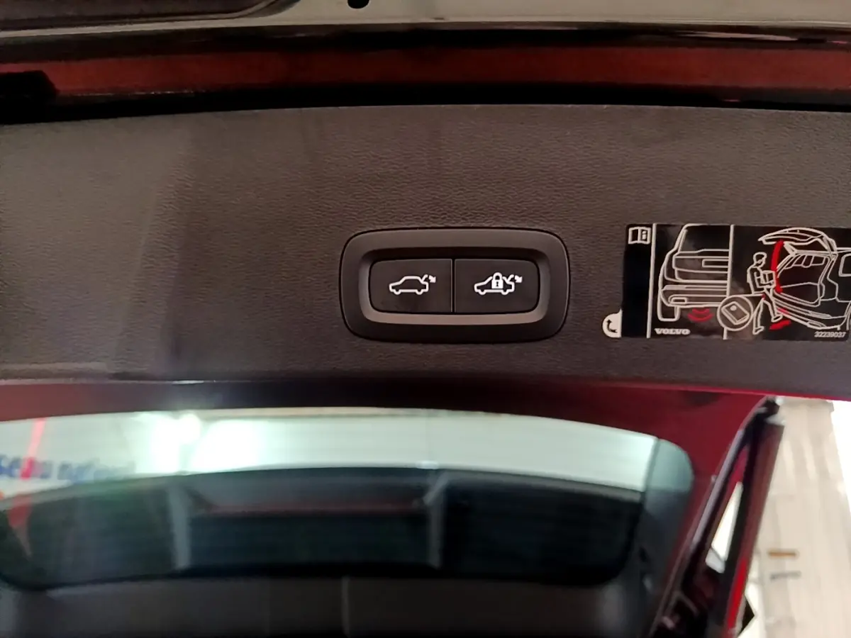 Boutons de commande d'ouverture et verrouillage du coffre sur la partie intérieure du hayon d'un Volvo XC40 noir.