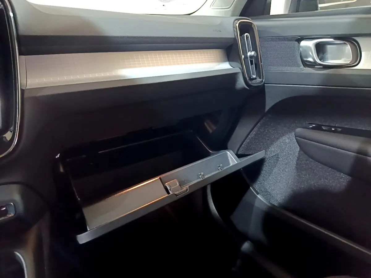 Vue intérieure côté passager du tableau de bord noir et boîte à gants ouverte du Volvo XC40 Recharge T4 2020.