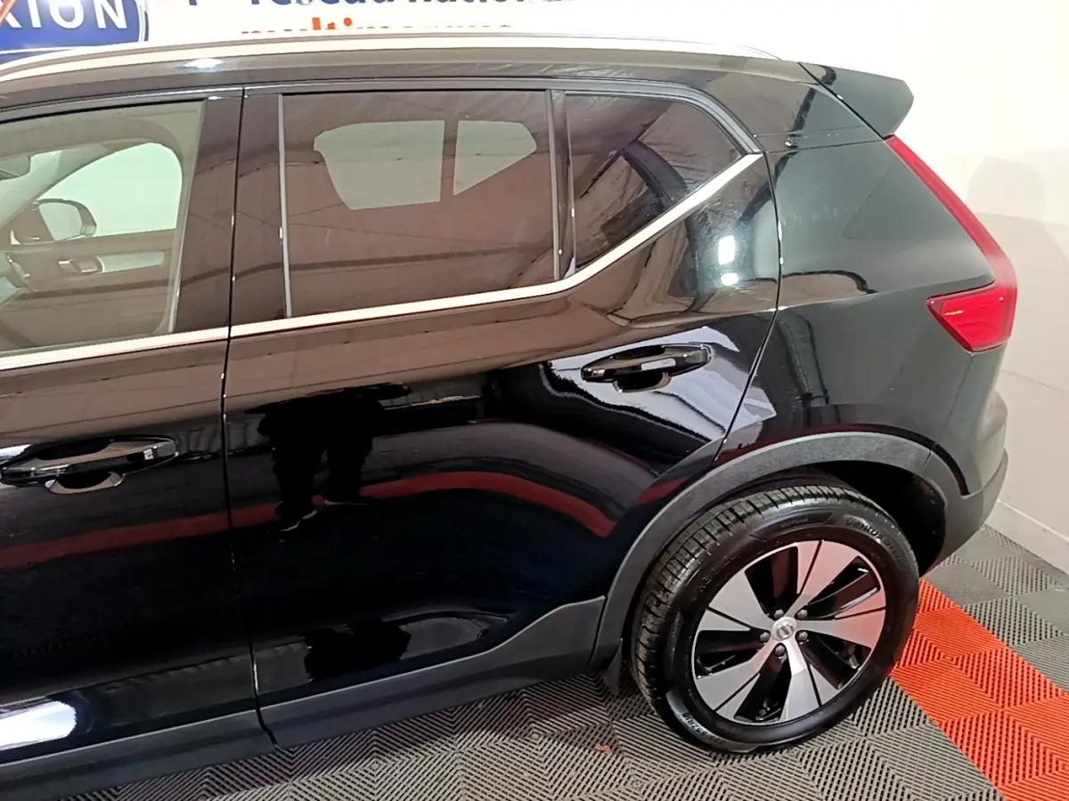 Vue latérale côté droit du Volvo XC40 Recharge T4 Business noir, mettant en valeur la ligne de toit et la roue arrière design.
