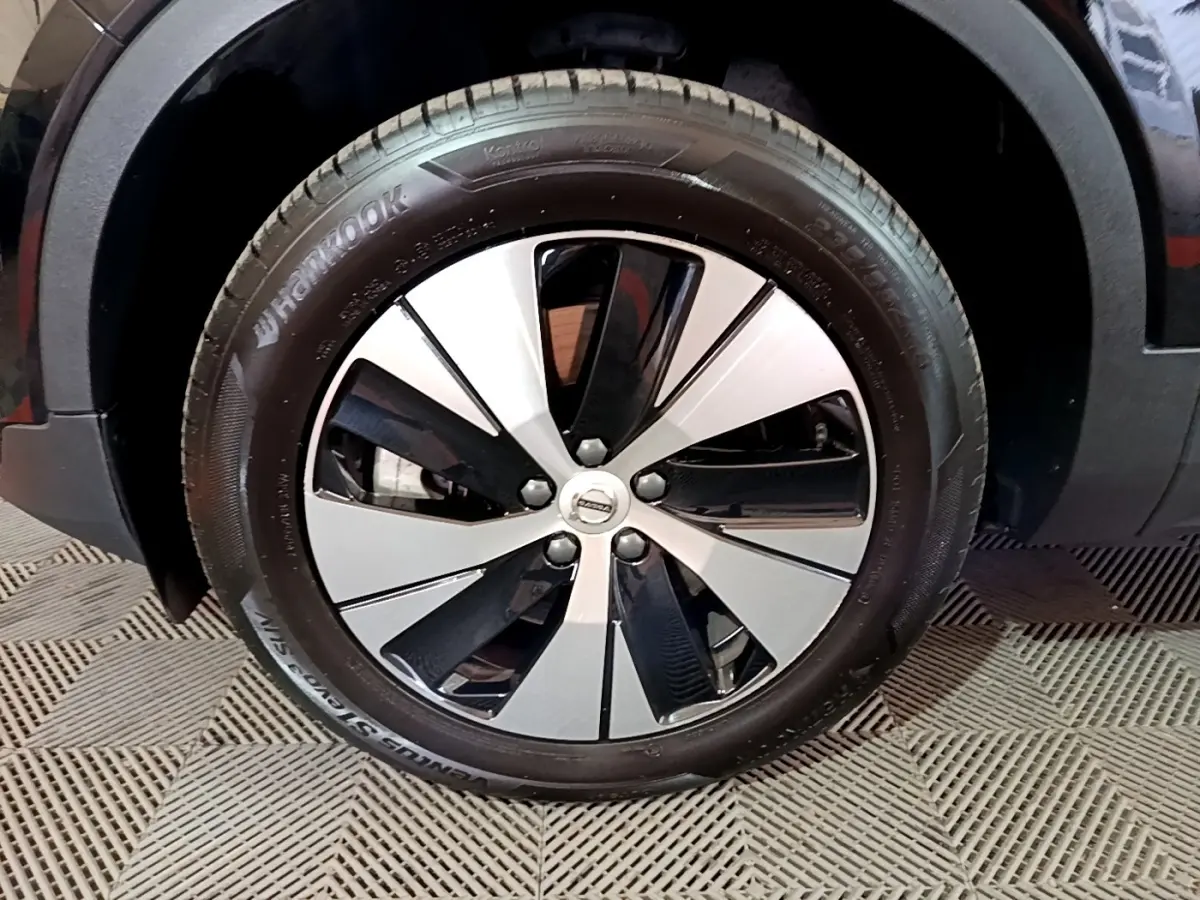 Gros plan sur la roue avant droite noire du Volvo XC40 Recharge T4 211 DCT7 Business avec jante bicolore moderne.