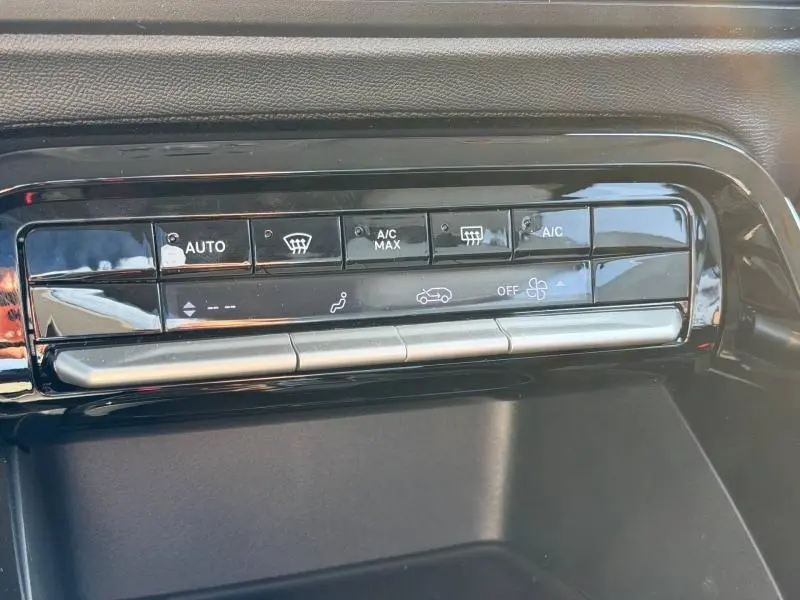 Panneau de commandes de climatisation automatique noir brillant dans une Citroën C3 Aircross gris Mercury, vue rapprochée.