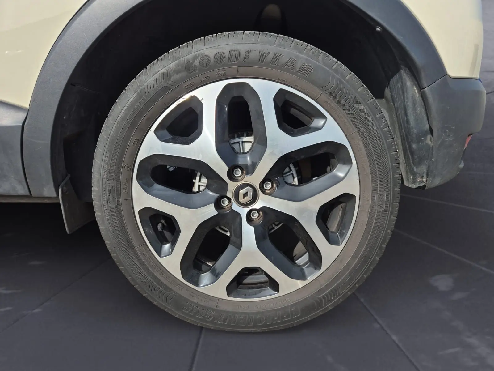 Gros plan sur la roue avant droite beige/marron d'un Renault Captur 2018 avec jante alliage à motifs noirs et argentés.