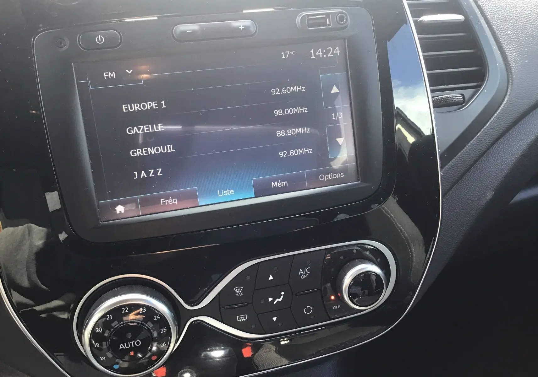 Vue rapprochée de la console centrale du Renault Captur 2018, affichant l’écran multimédia et les commandes de climatisation.