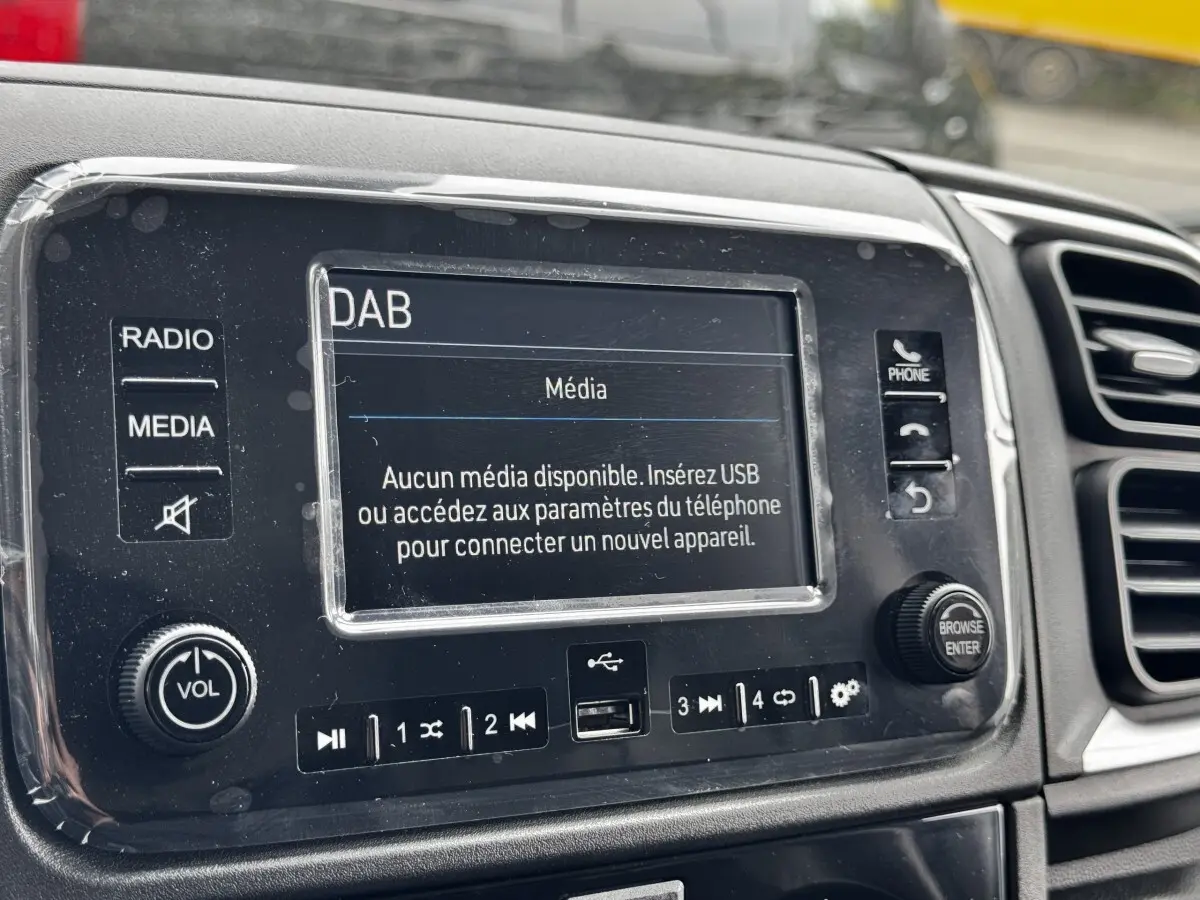 Gros plan sur l'écran tactile central du tableau de bord du Peugeot Boxer Fourgon blanc, affichant un message média.