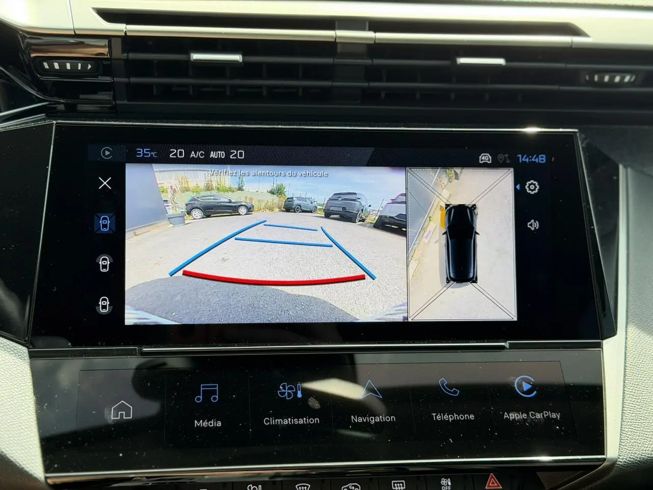 Écran tactile central montrant la caméra de recul et la vue 360° d'une Peugeot 308 Hybrid noire.