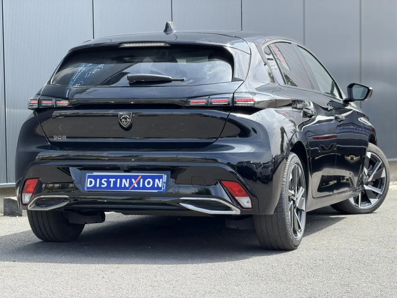 Vue 3/4 arrière droite de la Peugeot 308 Hybrid 145 noire Perla avec jantes alliage et feux LED distinctifs.