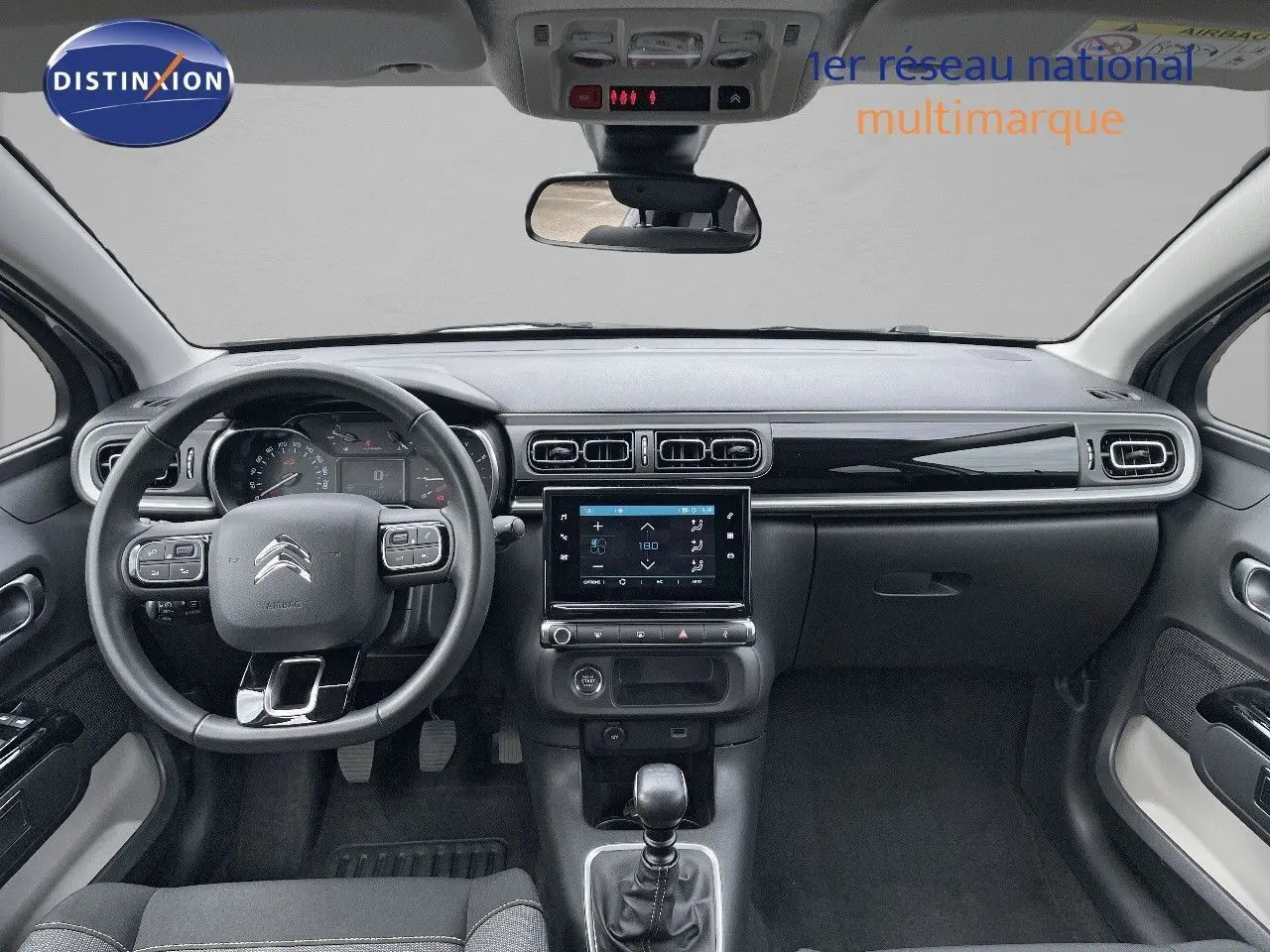 Intérieur avant de la Citroën C3 2021 gris avec tableau de bord moderne et boîte manuelle visible au centre.