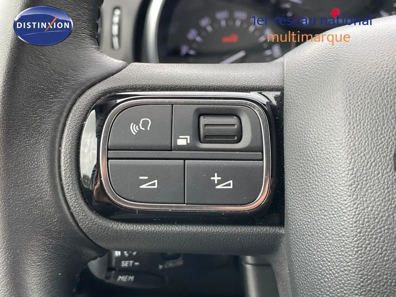 Gros plan sur les commandes au volant d'une Citroën C3 2021 gris Artense, mettant en valeur les boutons de réglage audio.