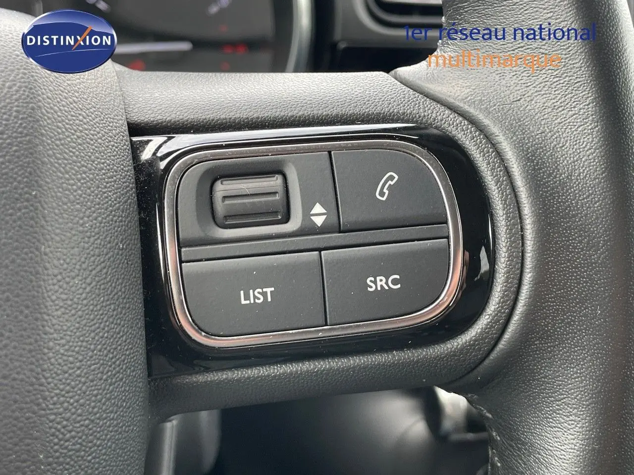 Gros plan sur les commandes du volant d'une Citroën C3 2021 gris Artense, boutons pour téléphone et audio visibles.