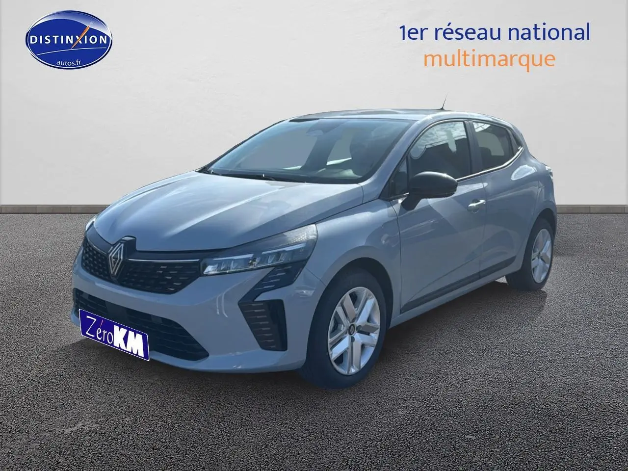 Renault Clio V gris rafale vue 3/4 avant droit, avec jantes alliage et coques de rétroviseurs noires.