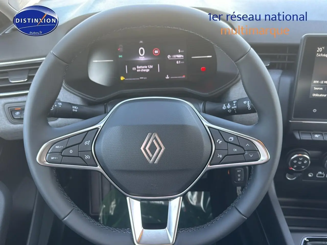 Vue rapprochée du volant cuir multifonctions de la Renault Clio V 1.5 dCi 100 gris rafale avec tableau de bord numérique.