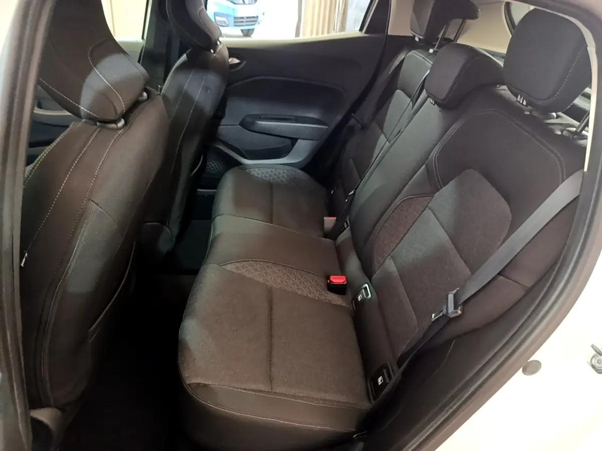 Vue intérieure des sièges arrière noirs d'une Renault Clio Business TCe 100 blanche, côté droit ouvert.