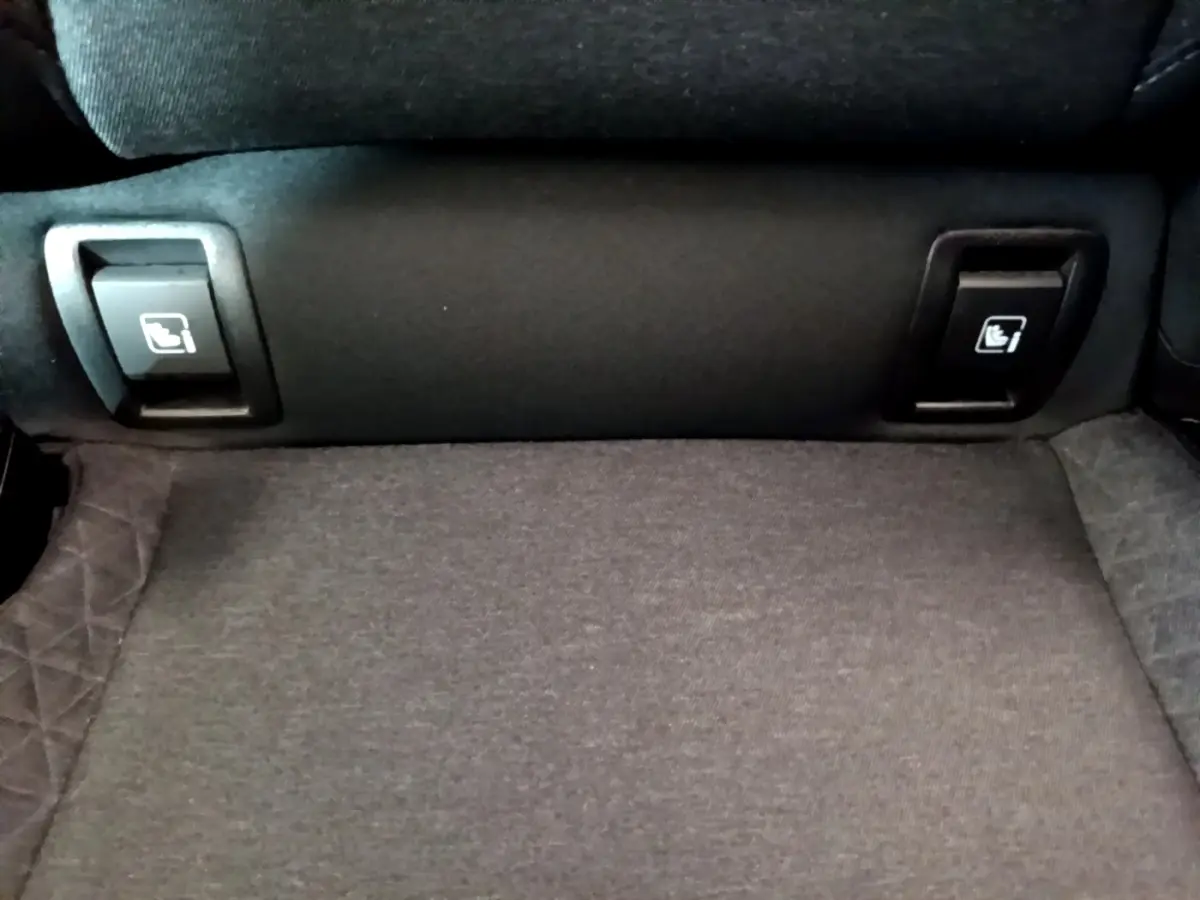 Gros plan sur les commandes de rabattement des sièges arrière du Renault Clio Business TCe 100, tissu gris.