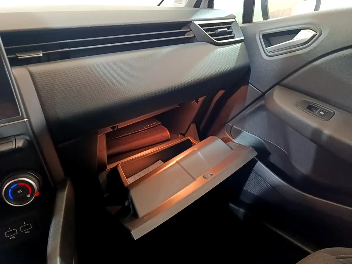 Intérieur de la Renault Clio Business TCe 100 2019, vue sur la boîte à gants ouverte côté passager, tableau de bord noir.