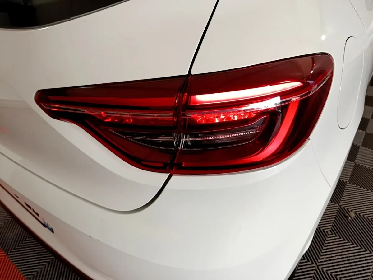 Feu arrière droit allumé d'une Renault Clio Business TCe 100 blanche, vue rapprochée sur l'arrière du véhicule.