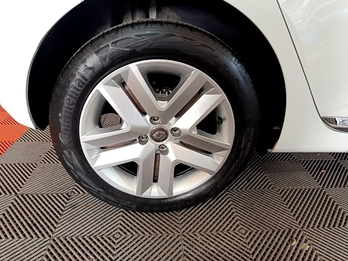 Gros plan sur la roue avant droite d'une Renault Clio Business TCe 100 blanche avec jante alliage moderne.