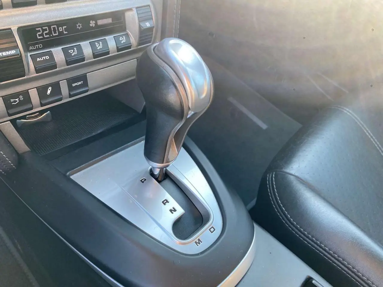 Gros plan sur la commande de boîte automatique Tiptronic en cuir et aluminium dans l'habitacle noir d'une Porsche 911 Carrera 4S 2007.
