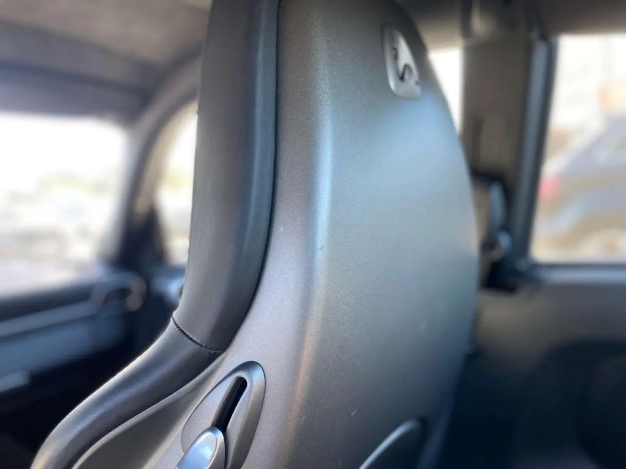 Gros plan sur le dossier avant en cuir gris d’une Porsche 911 997 Carrera 4S, intérieur cuir standard.